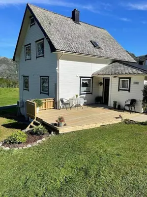 a large white house with a large wooden deck at Oceanview House Ideal for Peaceful Holidays in Venøya