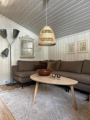 a living room with a couch and a table at Pen hytte nær Ål in Liagardane