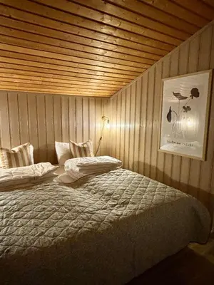a bedroom with a bed with a wooden ceiling at Pen hytte nær Ål in Liagardane