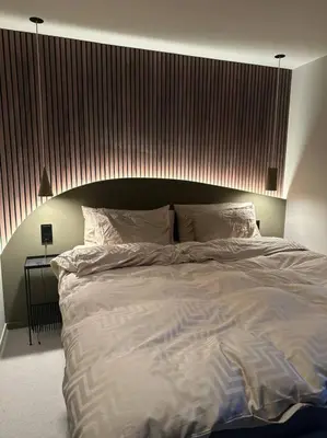 a bedroom with a large bed with a wooden headboard at Eksklusiv Enebolig in Bergen