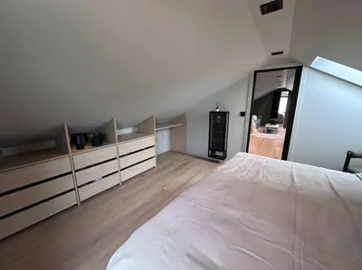 a bedroom with a large white bed and wooden floors at Eksklusiv Enebolig in Bergen