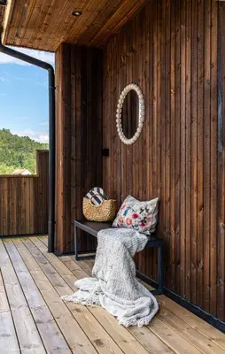 a wooden cabin with a bench on a deck at Eksklusiv Enebolig in Bergen