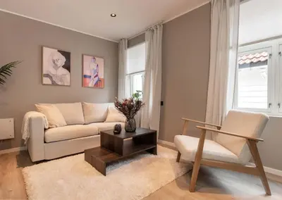 a living room with a couch and a chair at DINBNB Apartments l 50 meters to Bryggen l New 2023 l Sunny backyard in Bergen