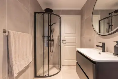 a bathroom with a shower and a sink and a mirror at DINBNB Apartments l 50 meters to Bryggen l New 2023 l Sunny backyard in Bergen