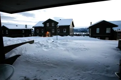 a yard covered in snow with houses in the background at Cozy Getaway Sauna and Terrace in Beitostøl
