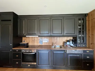 a kitchen with black cabinets and a sink at Cozy Getaway Sauna and Terrace in Beitostøl