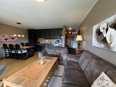 a living room with a couch and a table at Cozy Getaway Sauna and Terrace in Beitostøl