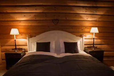 a bedroom with a bed with two lamps on tables at Phillipshaugen Lodge in Øksendalsøra