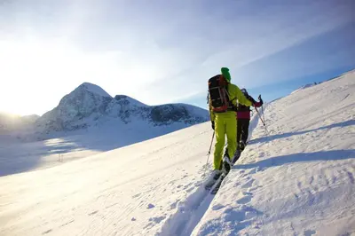 two people on skis walking up a snow covered mountain at Phillipshaugen Lodge in Øksendalsøra