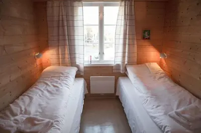 two beds in a small room with a window at Phillipshaugen Lodge in Øksendalsøra