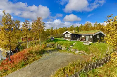 a house on a hill with a fence at Charming cabin Near Jotunheimen Trails in Beitostøl
