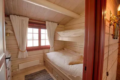 a bedroom with a bunk bed in a log cabin at Charming cabin Near Jotunheimen Trails in Beitostøl