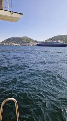 a boat in a large body of water with a ship at Central 1 bedroom apartment with a view in Bergen