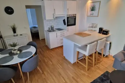 a kitchen and living room with a table and chairs at Central 1 bedroom apartment with a view in Bergen
