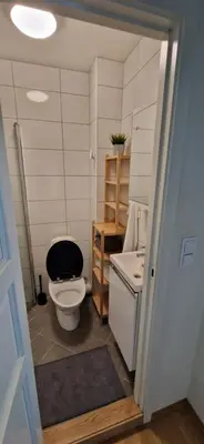 a bathroom with a toilet with a black seat at Central 1 bedroom apartment with a view in Bergen