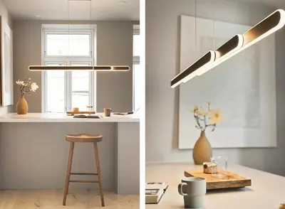 a kitchen with a counter with a stool and a pendant light at Stay l Nordnes in Bergen