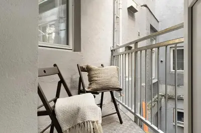 a chair sitting on a balcony next to a window at Stay l Nordnes in Bergen