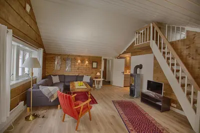 a living room with a couch and a staircase at Modern Comforts, and Ski Access in Beitostøl