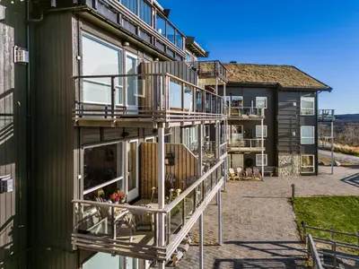 a house with a balcony on the side of it at Kikut Panorama Geilo Ski-in Ski-out in Geilo