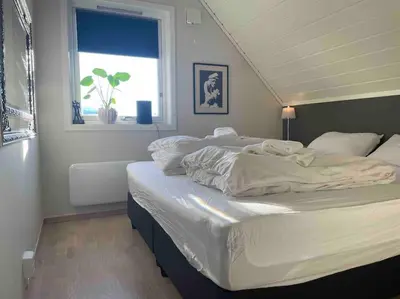 a large white bed in a bedroom with a window at Idyllisk hus i Vassenden sentrum in Vassenden