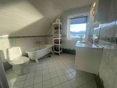 a bathroom with a tub and a toilet and a sink at Idyllisk hus i Vassenden sentrum in Vassenden