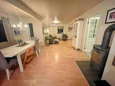 a living room with a table and a wood stove at Idyllisk hus i Vassenden sentrum in Vassenden