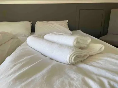 two towels sitting on top of a white bed at Idyllisk hus i Vassenden sentrum in Vassenden