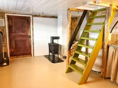 a room with a staircase and a stove in it at Unikt gårdshus - Gamlestua in Vestre Gausdal