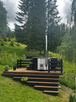 a stove on a wooden deck in a field at Unikt gårdshus - Gamlestua in Vestre Gausdal