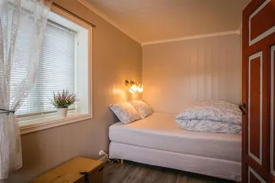 a small bedroom with a bed and a window at Unikt gårdshus - Gamlestua in Vestre Gausdal
