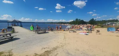a group of people on the beach at the beach at Koselig feriehus med jacuzzi i Nordre Osen, kun 40 minutter fra Trysil skianlegg in Åmot
