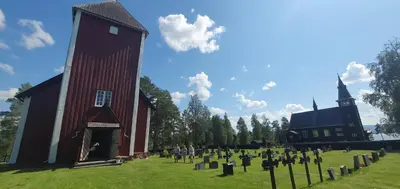 a group of people standing in a cemetery next to a church at Koselig feriehus med jacuzzi i Nordre Osen, kun 40 minutter fra Trysil skianlegg in Åmot