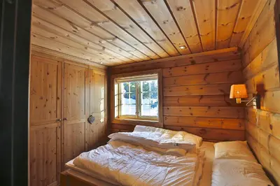 a room with a bed in a wooden room at Relaxing Getaway Sauna,Terrace and Pet friendly in Beitostøl