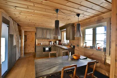 a kitchen with a table and chairs in a cabin at Relaxing Getaway Sauna,Terrace and Pet friendly in Beitostøl