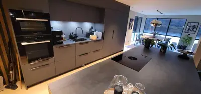 a kitchen with stainless steel appliances and a living room at Unique 3-Storey House in Trysil Luxury Living in the Heart of the Village in Trysil