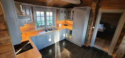 a kitchen with blue cabinets and a sink at The Whole Beautiful Cabin With Jacuzzi A Luxurious Getaway in Solberglia in Østby