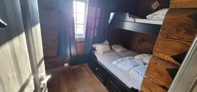a bedroom with two bunk beds and a window at The Whole Beautiful Cabin With Jacuzzi A Luxurious Getaway in Solberglia in Østby