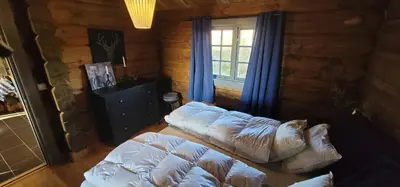 a room with two beds in a log cabin at The Whole Beautiful Cabin With Jacuzzi A Luxurious Getaway in Solberglia in Østby