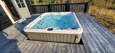 a hot tub sitting on a deck at The Whole Beautiful Cabin With Jacuzzi A Luxurious Getaway in Solberglia in Østby