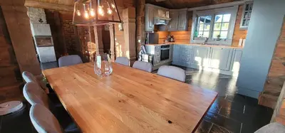 a wooden table and chairs in a kitchen at The Whole Beautiful Cabin With Jacuzzi A Luxurious Getaway in Solberglia in Østby