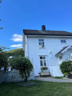 a white house with a bench in front of it at Exclusive 1920 century villa 10 min from AirPort in Malvik