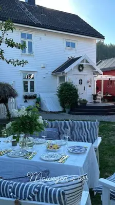 a table with plates of food on it in front of a house at Exclusive 1920 century villa 10 min from AirPort in Malvik
