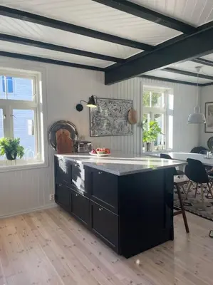 a kitchen with a black island in a room at Exclusive 1920 century villa 10 min from AirPort in Malvik
