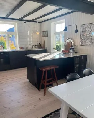 a large kitchen with a counter and a table at Exclusive 1920 century villa 10 min from AirPort in Malvik