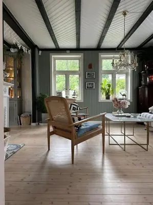a living room with a table and a chair at Exclusive 1920 century villa 10 min from AirPort in Malvik