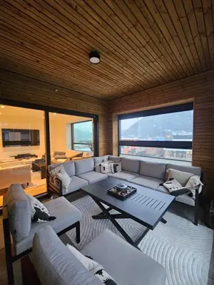 a living room with a couch and a table at Toppleilighet på elvekanten med to romslige soverom in Førde