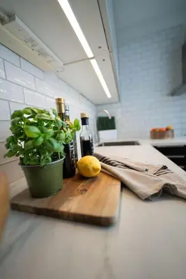 a cutting board with bottles of wine and a plant at Ultra central flat with balcony in Bergen