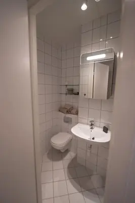 a white bathroom with a toilet and a sink at Ultra central flat with balcony in Bergen