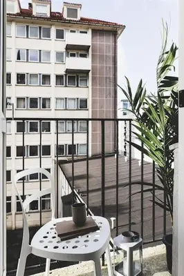 a table and chairs on a balcony with a building at Ultra central flat with balcony in Bergen