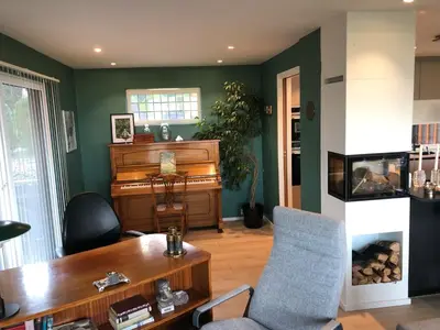 a living room with a piano and a chair at Sjarmerende enebolig in Trondheim